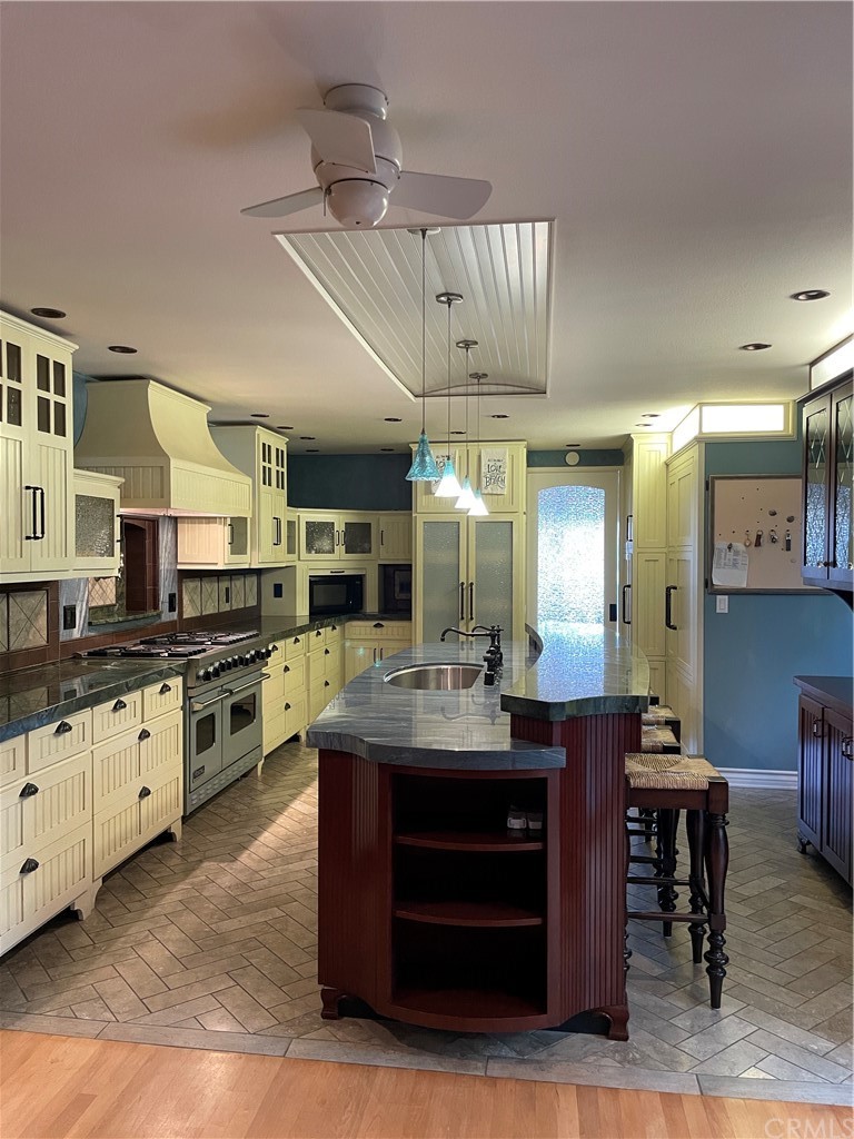 239 16th Street Seal Beach, CA 90740 - Photo 7 of 11 a kitchen with kitchen island granite countertop a sink cabinets and stainless steel appliances