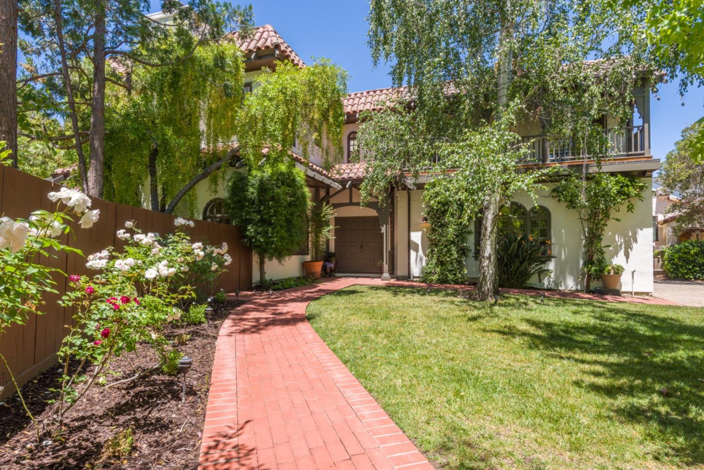 a backyard of a house with table and chairs and potted plants