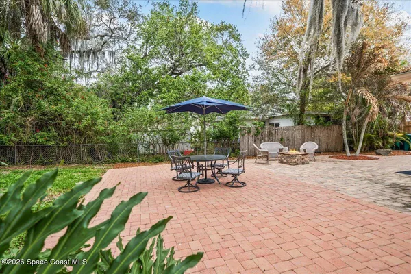 a view of a patio with a table and chairs under an umbrella
