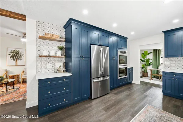 a large living room with stainless steel appliances granite countertop a couch wooden floor and a view of living room