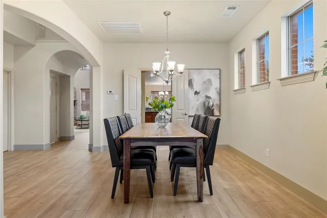 a dining room with furniture potted plants and wooden floor