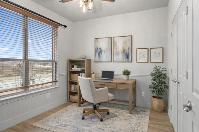 a view of a workspace with furniture and a window