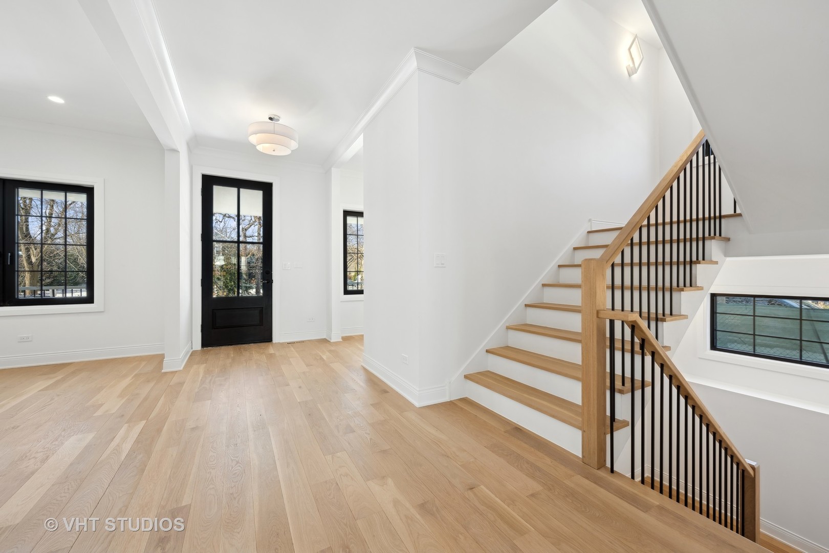 399 Ridge Avenue Winnetka, IL 60093 - Photo 3 of 45 a view of a hallway with wooden floor and stairs