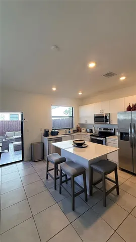 a kitchen with a dining table chairs and a refrigerator