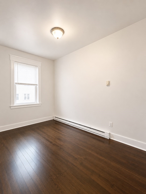746 Broadway, Unit 2 Chelsea, MA 02150 - Photo 2 of 13 a view of an empty room with wooden floor and a window