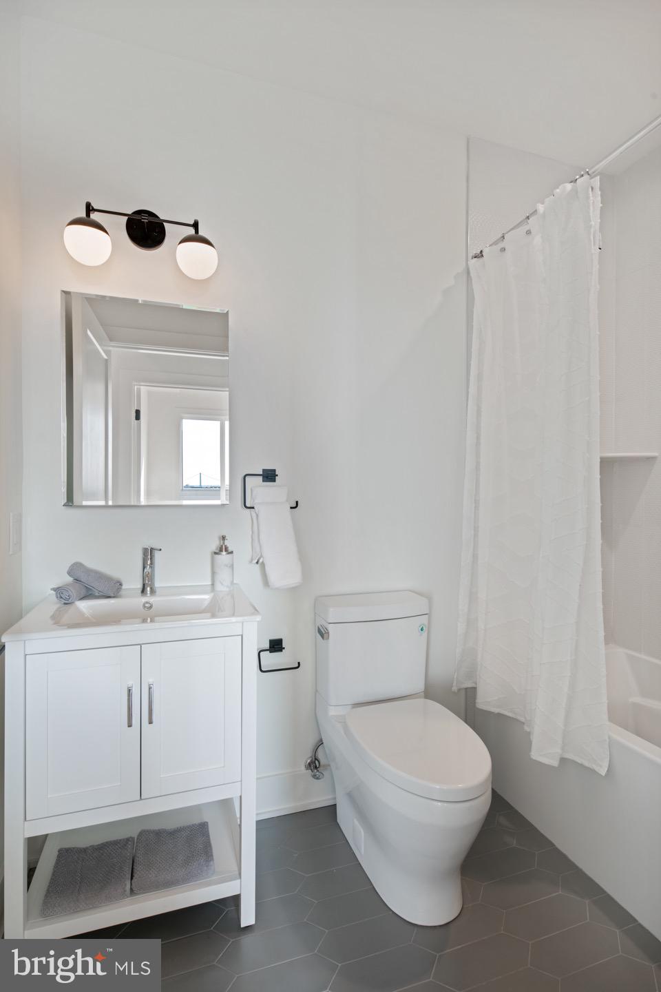 1822 North Front Street, Unit 8 Philadelphia, PA 19122 - Photo 19 of 23 a bathroom with a toilet a sink and mirror