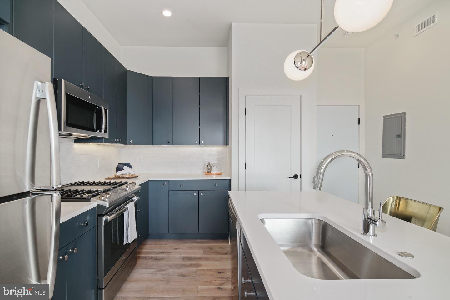 1822 North Front Street, Unit 8 Philadelphia, PA 19122 - Photo 5 of 23 a kitchen with granite countertop a sink stainless steel appliances and cabinets