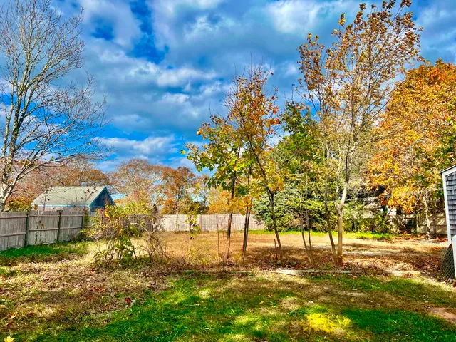 a view of yard with tree and wooden fence