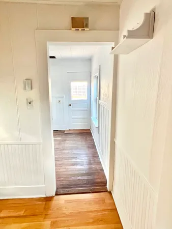 a view of a hallway with wooden floor and entryway