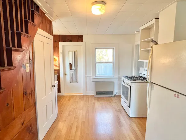 a kitchen with a refrigerator a stove top oven a sink and dishwasher with wooden floor