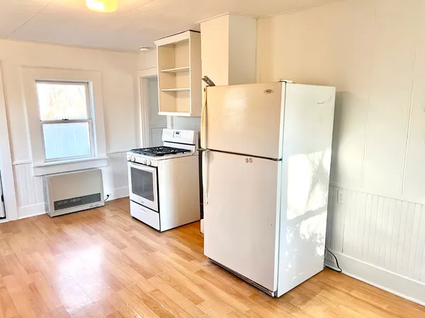 a white refrigerator freezer and a wooden floor