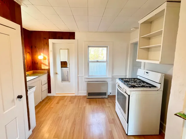 a kitchen with a wooden floor and a stove top oven