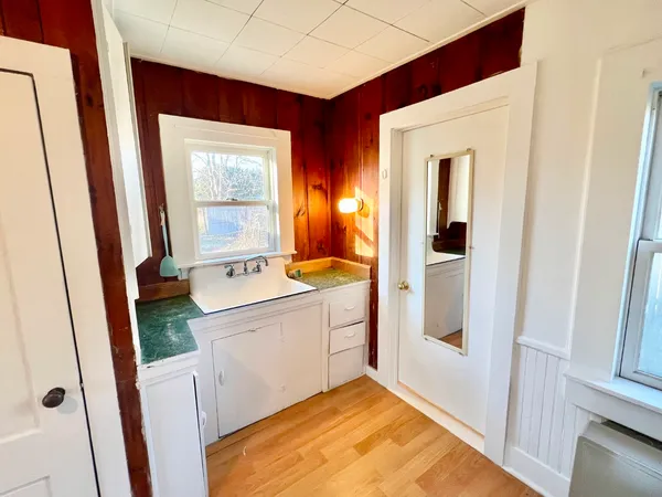 a view of bathroom with a sink and mirror next to a window