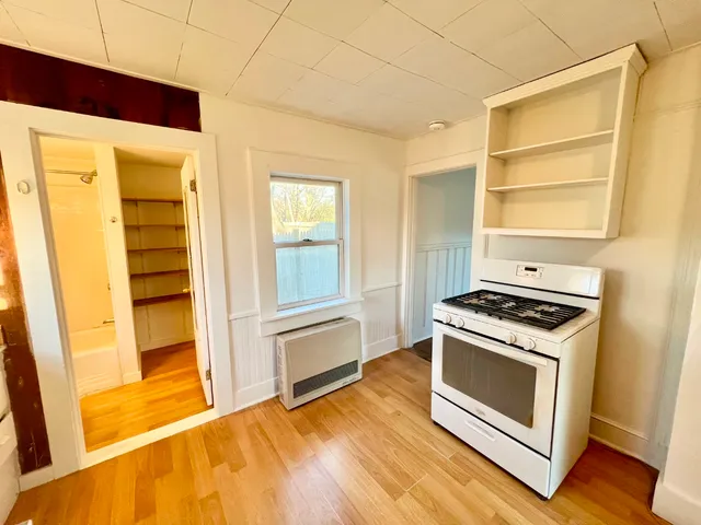 a kitchen with a stove and a white cabinet