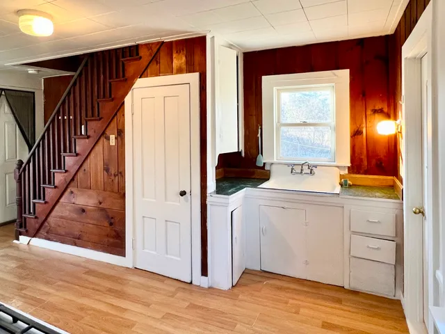 a view of a hallway and closet with wooden floor