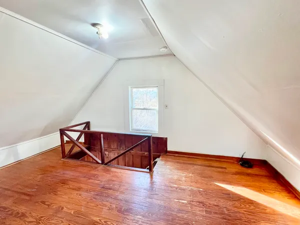 a room with wooden floor and pool table