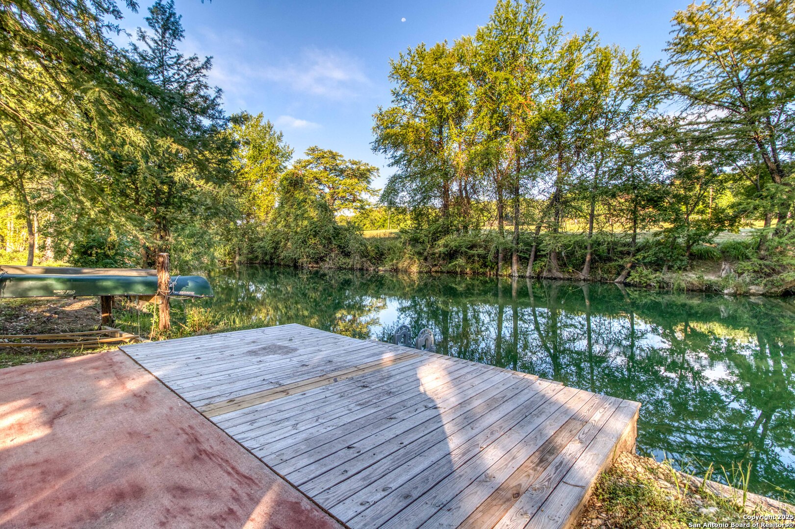 a view of a wooden deck with lake view