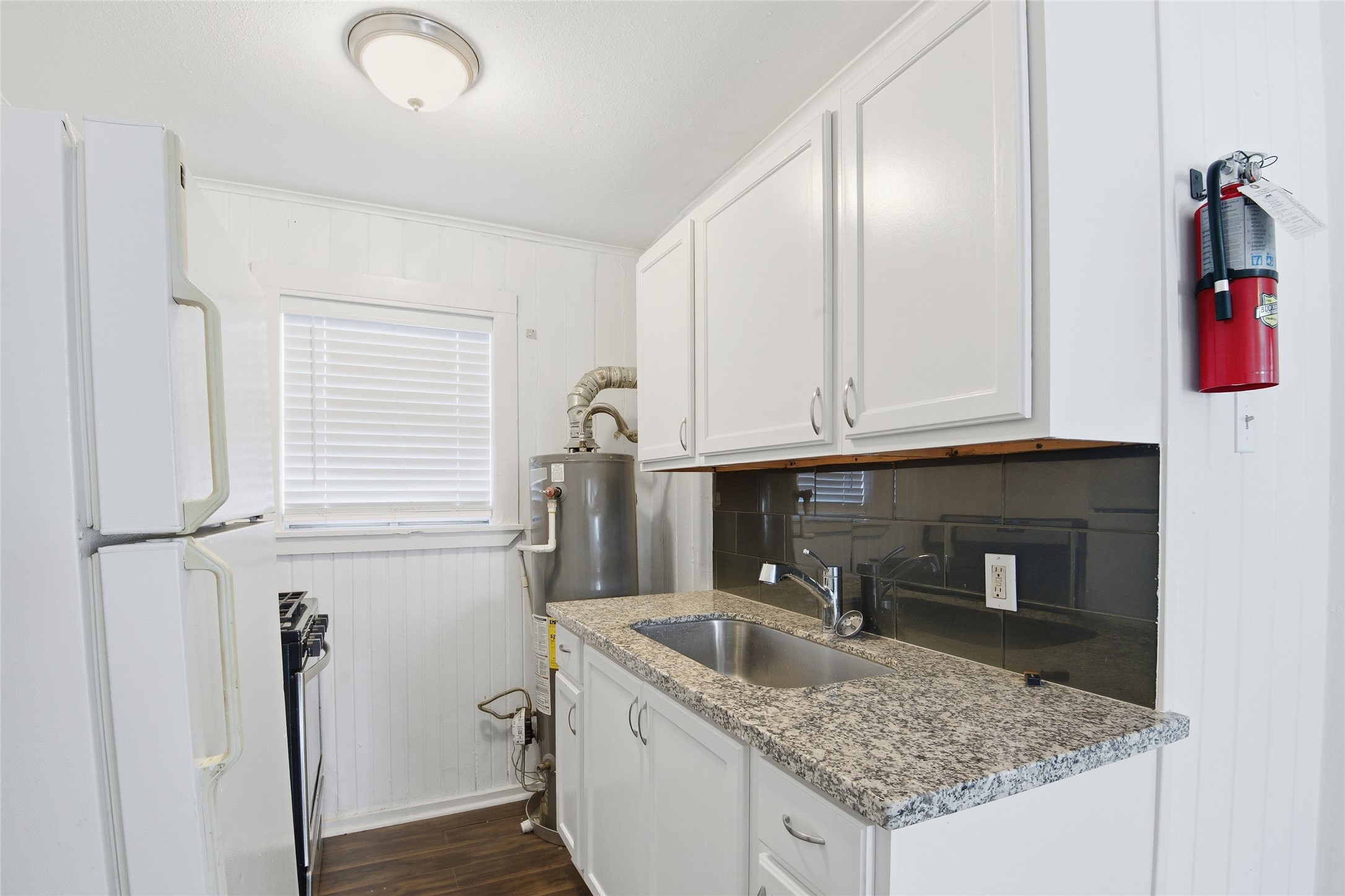 5010 Ennis Street, Unit 2 Houston, TX 77004 - Photo 7 of 11 a kitchen with a granite countertop sink and cabinets