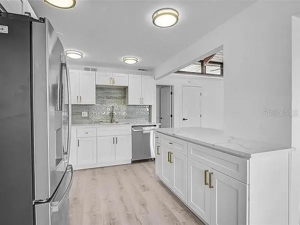 a kitchen with granite countertop white cabinets white stainless steel appliances with a sink and dishwasher