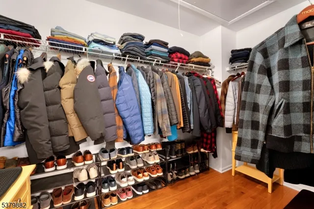 a view of walk in closet with clothes and shoes