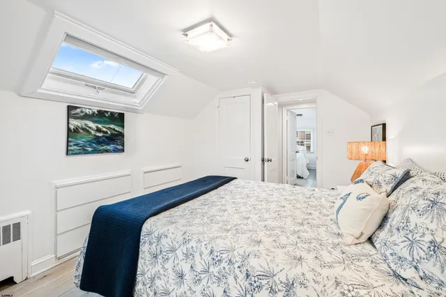 a bedroom with a bed and a painting on the wall