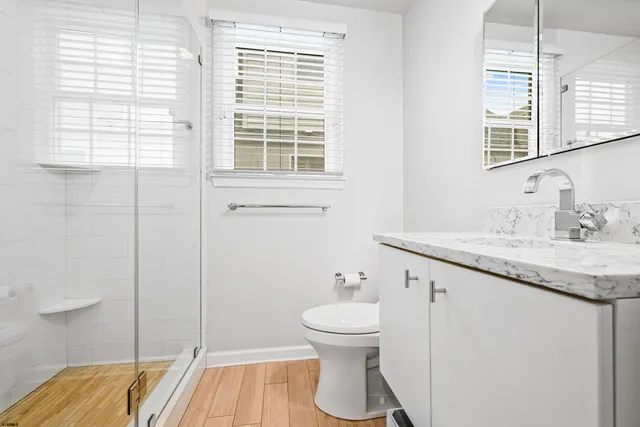 a bathroom with a granite countertop sink toilet and shower