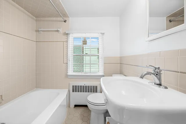 a bathroom with a sink and bathtub with toilet