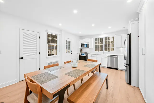 a living room with stainless steel appliances kitchen island granite countertop furniture and wooden floor