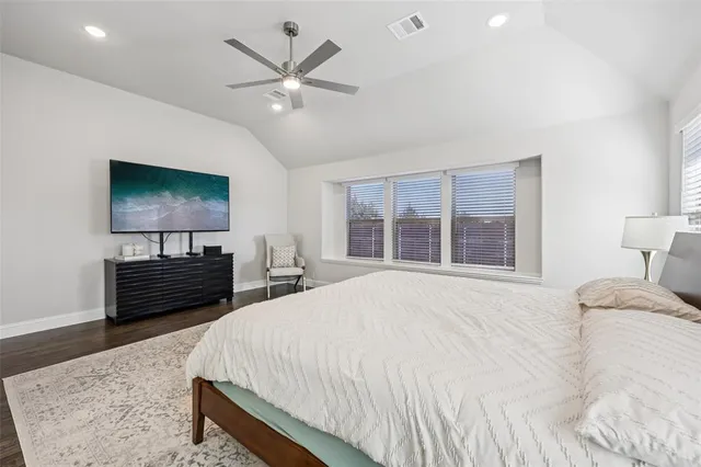 a bedroom with a bed a dresser and a flat screen tv