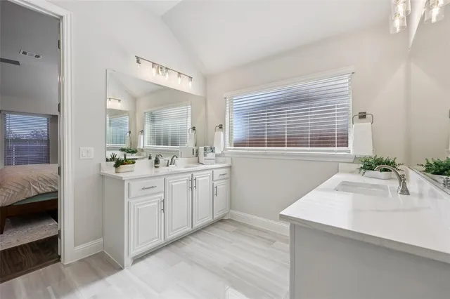 a spacious bathroom with a sink double vanity and a mirror
