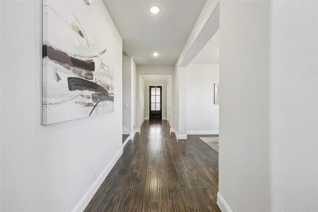a view of a hallway with wooden floor