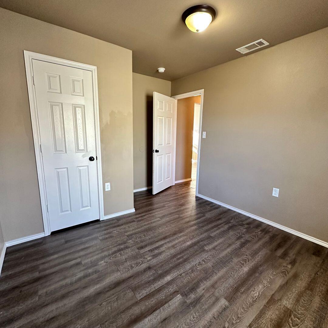 113 36th Street, Unit 2 Lubbock, TX 79404 - Photo 4 of 8 a view of empty room with wooden floor and entryway
