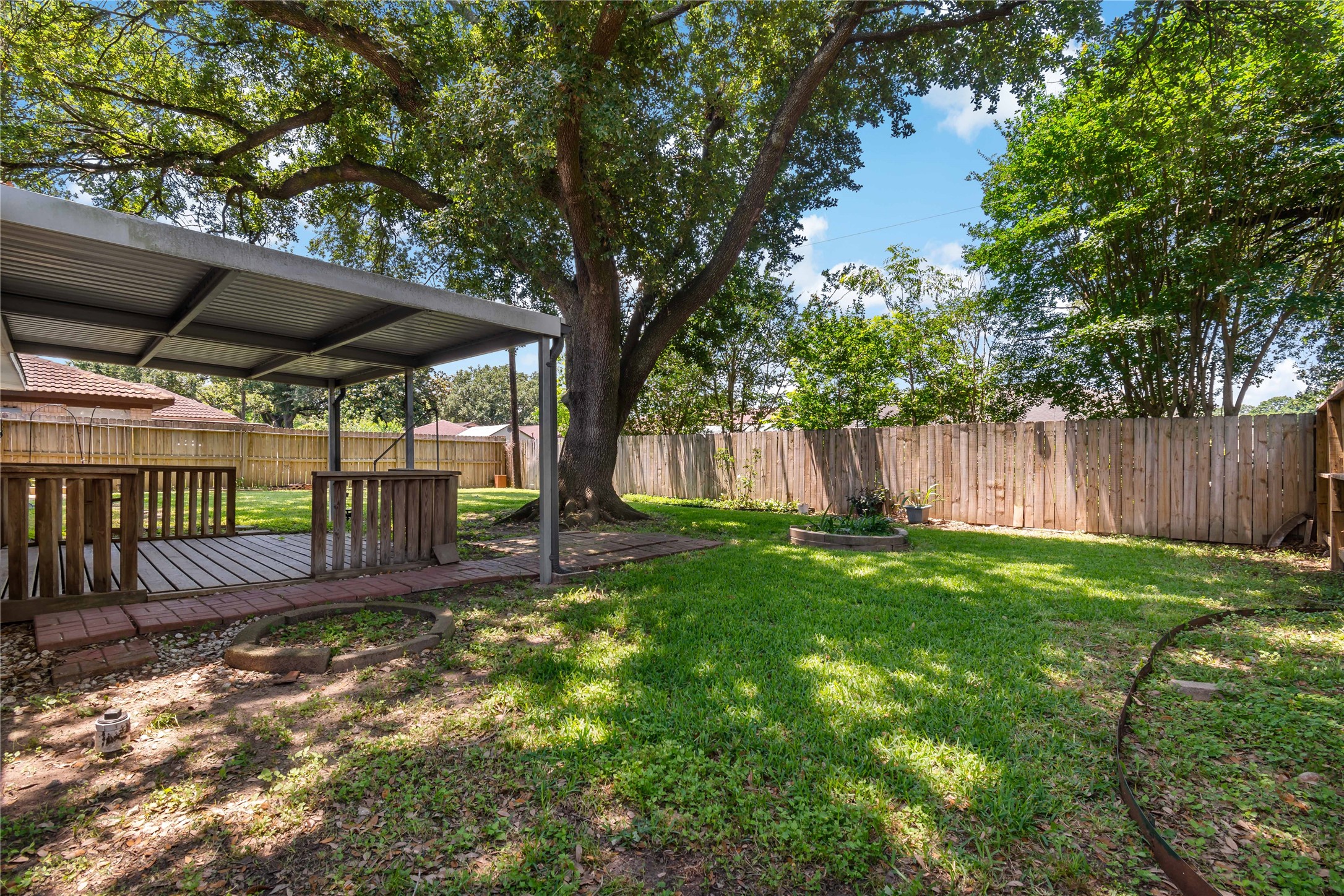 4302 Seneca Street Pasadena, TX 77504 - Photo 17 of 19 a view of a backyard with wooden fence and a large tree