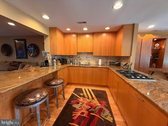 a kitchen with kitchen island granite countertop a sink and a stove