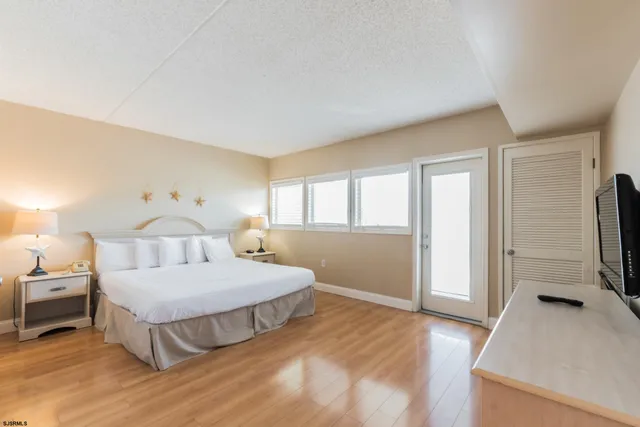 a bedroom with a bed and a flat tv screen on the dresser