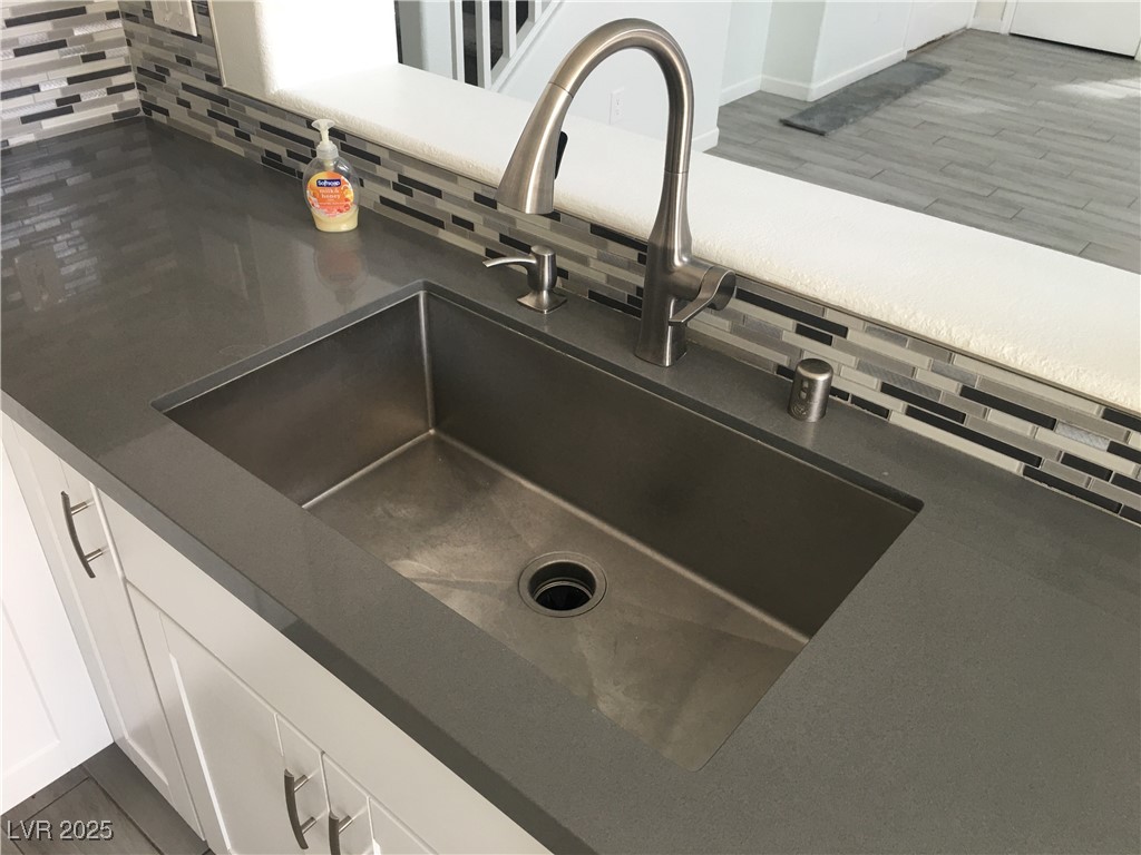 973 Cedar Pines Street Henderson, NV 89011 - Photo 12 of 37 Kitchen view of white cabinets, backsplash, and dark countertops