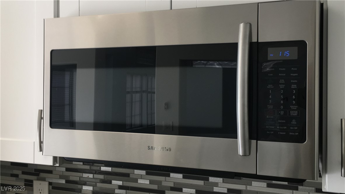 973 Cedar Pines Street Henderson, NV 89011 - Photo 14 of 37 Kitchen view of stainless steel microwave and decorative backsplash