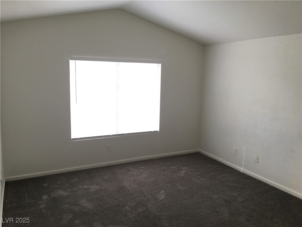 973 Cedar Pines Street Henderson, NV 89011 - Photo 19 of 37 Unfurnished room featuring dark colored carpet and vaulted ceiling