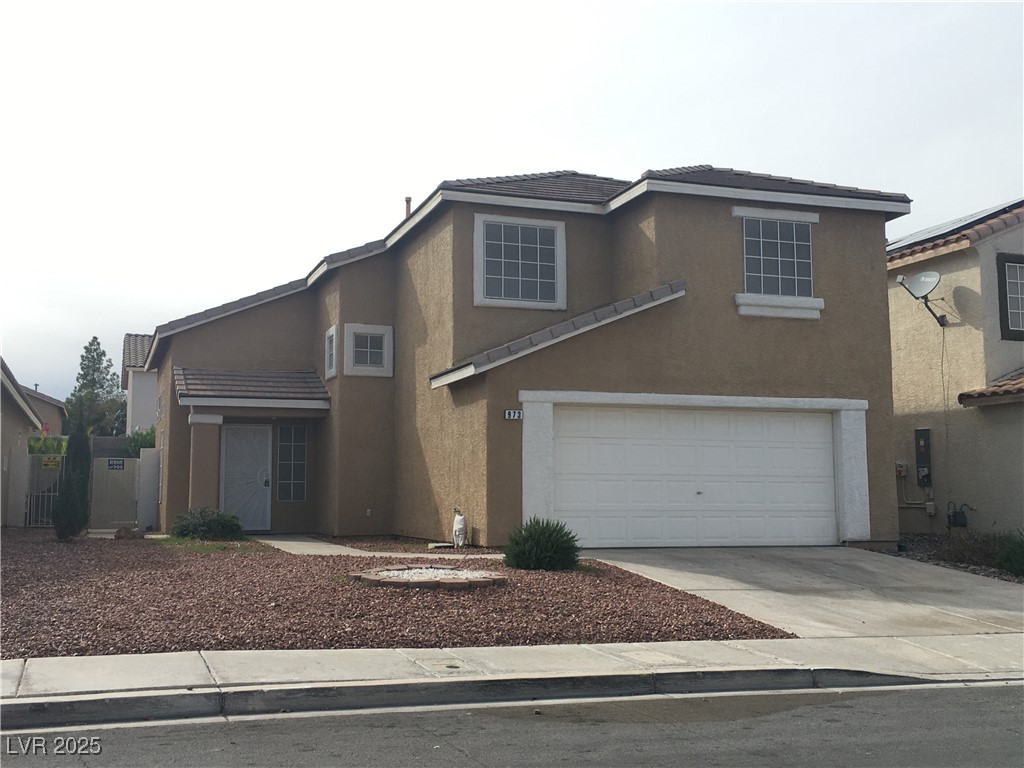 973 Cedar Pines Street Henderson, NV 89011 - Photo 2 of 37 Traditional-style house with stucco siding, driveway, a tiled roof, and a garage