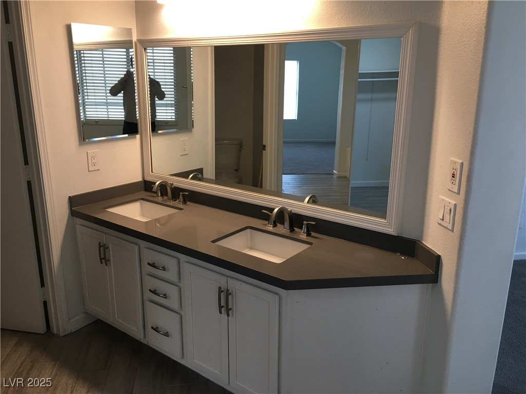 973 Cedar Pines Street Henderson, NV 89011 - Photo 24 of 37 Bathroom featuring double vanity, a textured wall, and dark wood finished floors