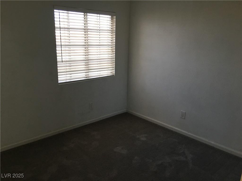 973 Cedar Pines Street Henderson, NV 89011 - Photo 25 of 37 Empty room with dark colored carpet and baseboards