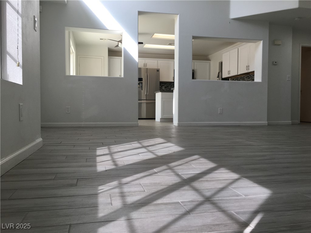 973 Cedar Pines Street Henderson, NV 89011 - Photo 4 of 37 Unfurnished living room with baseboards and light wood-style floors