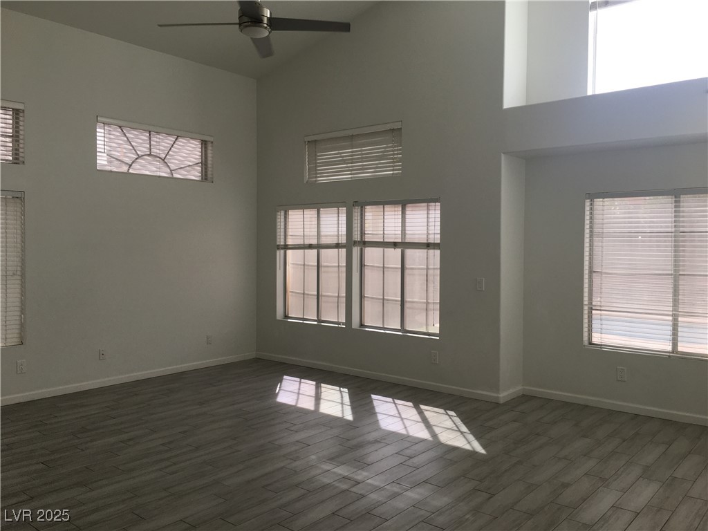 973 Cedar Pines Street Henderson, NV 89011 - Photo 6 of 37 Spare room with high vaulted ceiling, ceiling fan, and dark wood finished floors