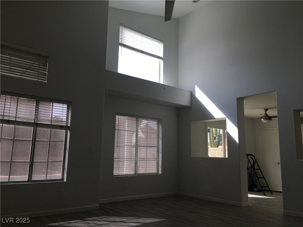 973 Cedar Pines Street Henderson, NV 89011 - Photo 7 of 37 Unfurnished living room featuring ceiling fan, a towering ceiling, and dark wood-type flooring