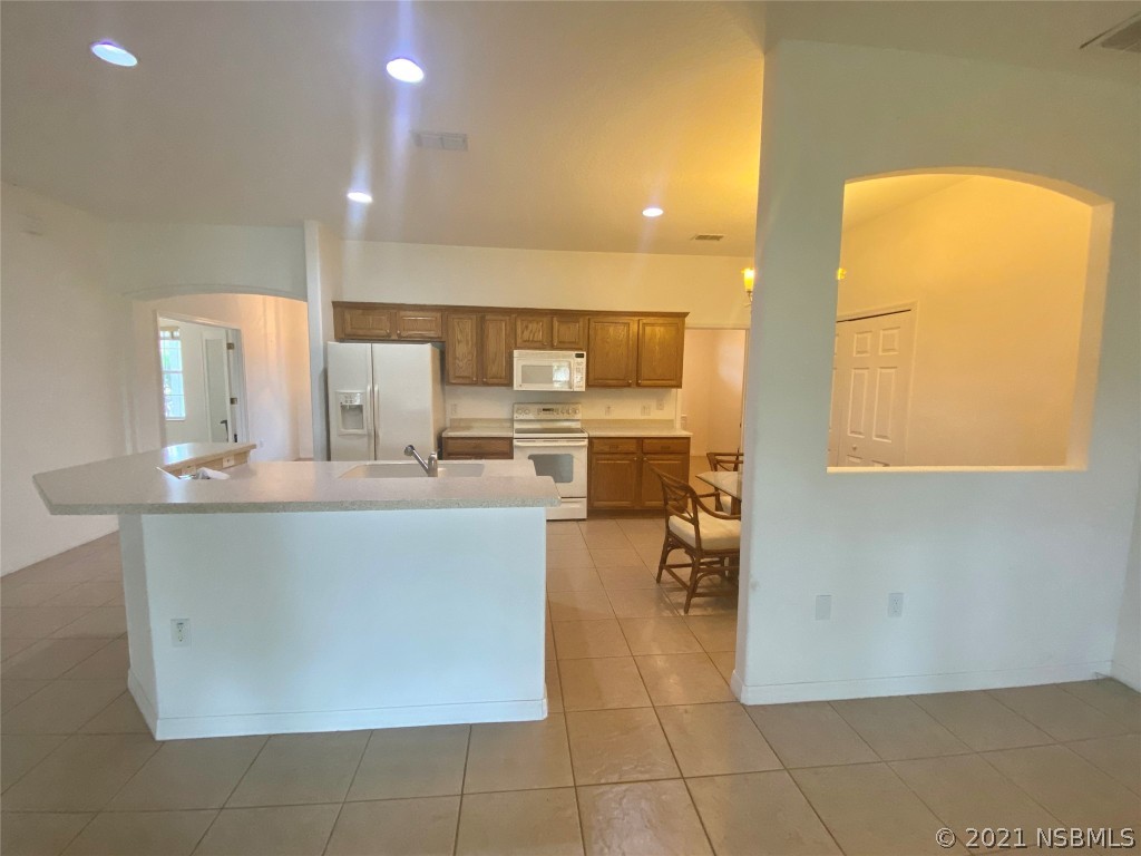 339 Mariners Gate Drive Edgewater, FL 32141 - Photo 17 of 30 a living room with stainless steel appliances kitchen island granite countertop a table and chairs in it