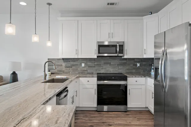 a kitchen with kitchen island granite countertop a stove sink and refrigerator