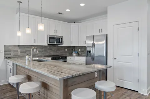 a kitchen with a sink a stove a refrigerator and cabinets