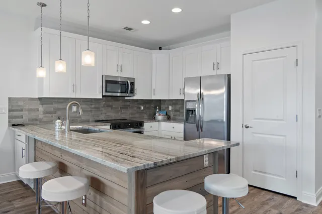 a kitchen with a sink a stove a refrigerator and cabinets