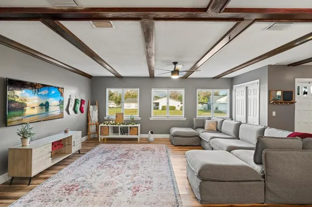 a living room with furniture a flat screen tv and a floor to ceiling window