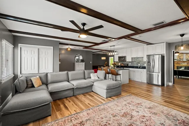 a living room with furniture and kitchen view
